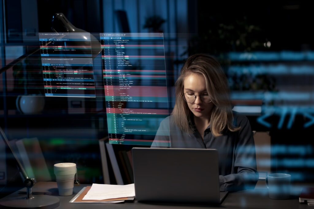 A person programming at the desk with codes on the laptop