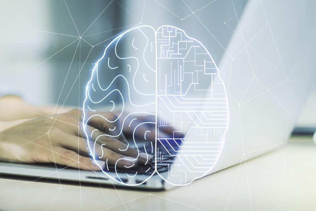 person typing on the keyboard of a laptop and graphics rapresenting a brain