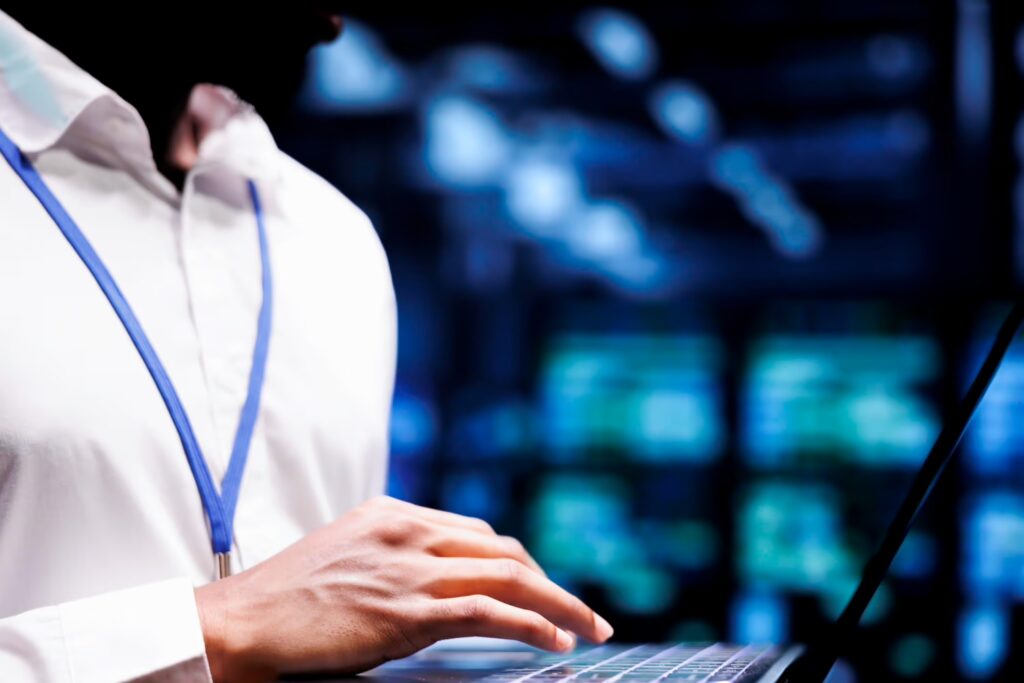 person using laptop inside a data center